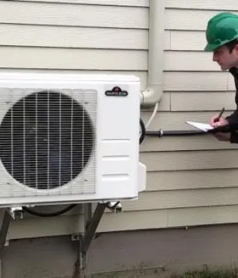 personne regardant une pompe à chaleur à l'extérieur
