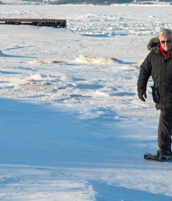 Male and female snowshoeing in winter in North Rustico, PEI
