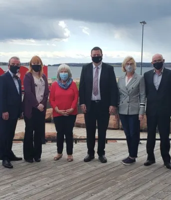 image of eight people standing shoulder to shoulder