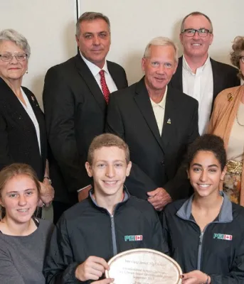 Photo shows a group of people and three are holding plates representing the three environmental awards.