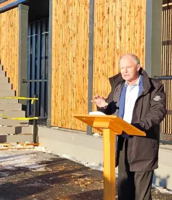 image of a person speaking at a podium outside a building