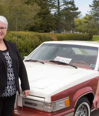 Three people standing in front of car