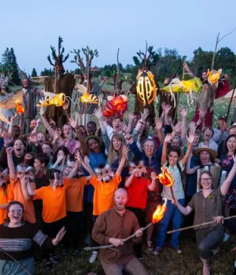 image d'un groupe de personnes avec les mains levées dans un champ
