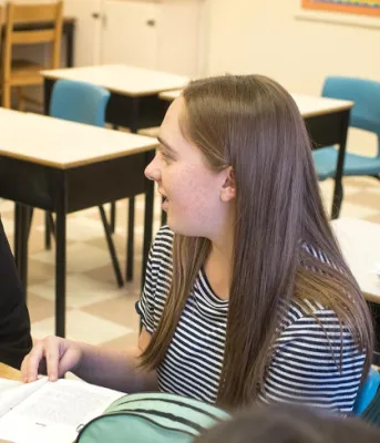 Birchwood teacher Frances Ann Squire sits at a table talking with two students
