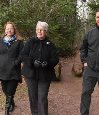 Minister Biggar and two other people walking near newly neamed trail in Bonshaw.