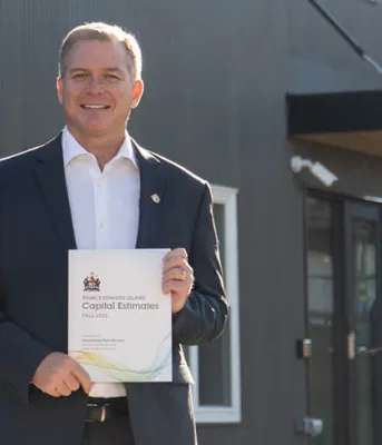 image of a person holding a document while in front of a building
