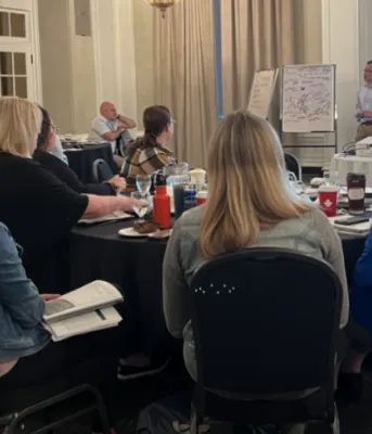 Employees in training, seated at tables