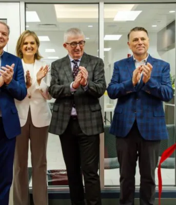 image of four people clapping their hands after a ribbon cutting ceremony