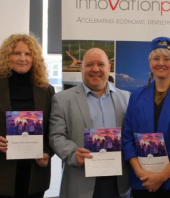 image de cinq personnes debout côte à côte tenant des programmes de couleurs