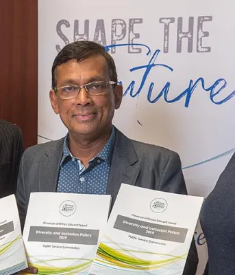 Three people standing shoulder to shoulder holding new documents in their hands