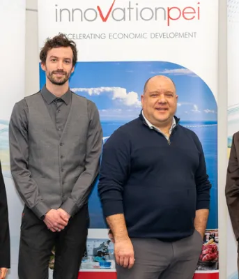 image of five people standing inside a building shoulder to shoulder in front of a backdrop