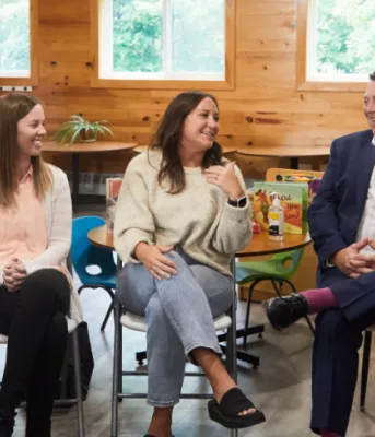 image de cinq adultes assis sur des chaises dans une garderie