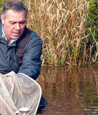 Minister Mitchell releasing fish into a river