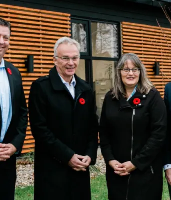 image of four people standing in front of a building