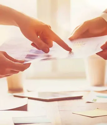 Photo shows people handing each other papers