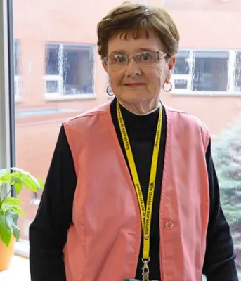 image d'une personne debout devant une fenêtre donnant sur une cour