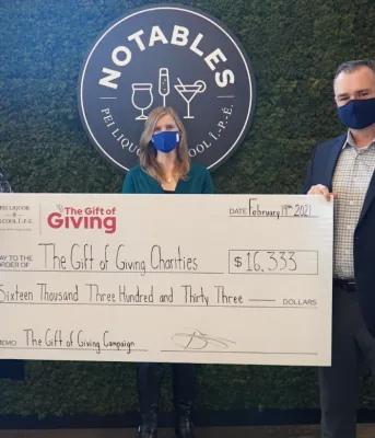 image of three people standing holding a large cheque in front of them.