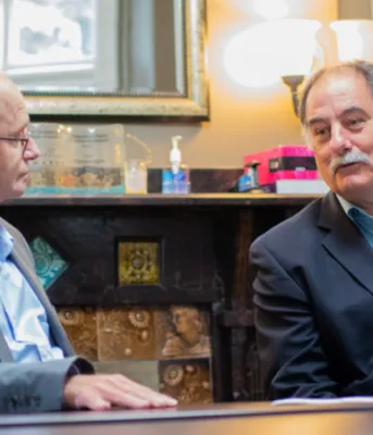 Two people seated at a table talking