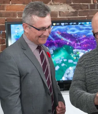 Minister MacDonald and  MP Sean Casey look at tablet heald by icejam founder Stu Duncan