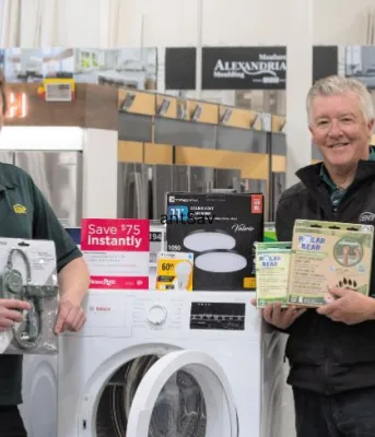 image of two employees in a store standing in front of a washer and dryer