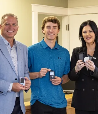 Image of 3 pople holding insulin pump