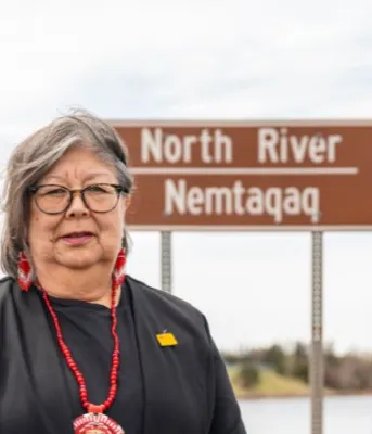 image of person standing on a bridge with a road sign in the background