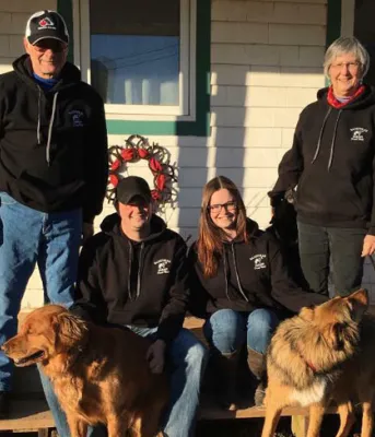 MacKinnon family and their dogs on the outside front step of their home