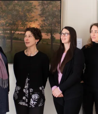 Minister Compton standing speaking to four women about the new booklet