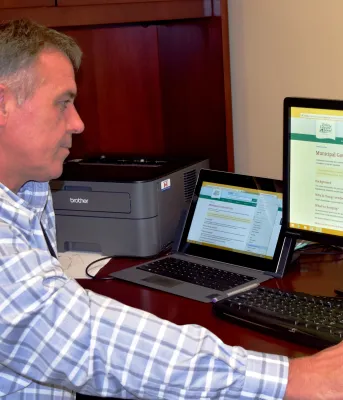 Minister of Communities, Land and Environment Robert Mitchell reviews the new department webpage that invites Islanders to submit feedback on the upcoming Municipal Government Act.