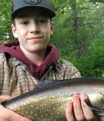 image of a boy holding a fish in front of his body