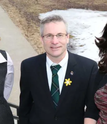 Minster Henderson and two people standing in fronot of Coles Building