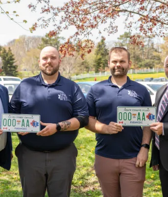 photo of four people, with license plates 