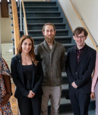 image of people standing shoulder to shoulder in a building at the bottom of stairs