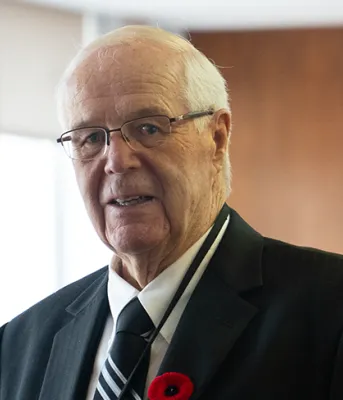 Head and shoulder photo of former Premier Jim Lee. He is wearing a dark suit and a poppy.