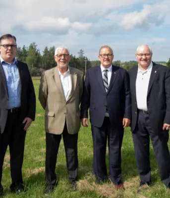 Four men standing shoulder to shoulder in a field