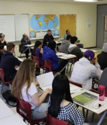 Grade 12 students Connor Crosby and Young Hao Yu stand making a presentation to their Global Issues class at Colonel Gray