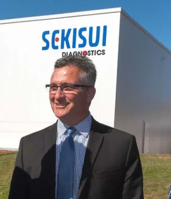 Minister Heath MacDonald and two men standing in from of Sekisui Diagnostics building