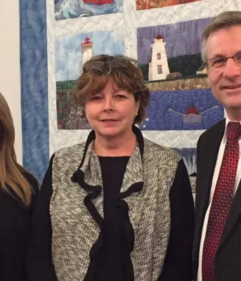 Minister Mundy and two others stand beside each other.