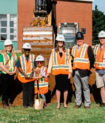 image of people standing shoulder to shoulder in front of a school