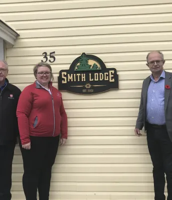 Image of three people standing in front of a building