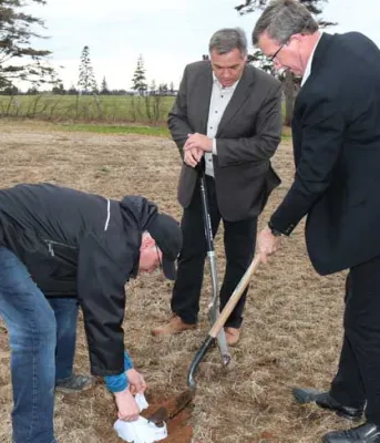 Environment Minister Robert Mitchell and Agriculture Minister Alan McIsaac bury a pair of white cotton brief to test the quality of Island soil