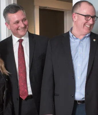 Two men and two women stand chatting about new affordable housing units in Summerside 