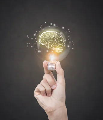 Hand holding glowing light bulb