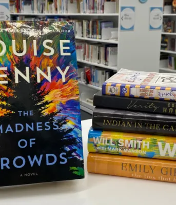 image of some books on a table and rows of books in a library in the background