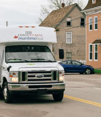 image of a small transit bus on a street in a village