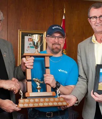 Five people holding Premiers Tuna Cup trophy