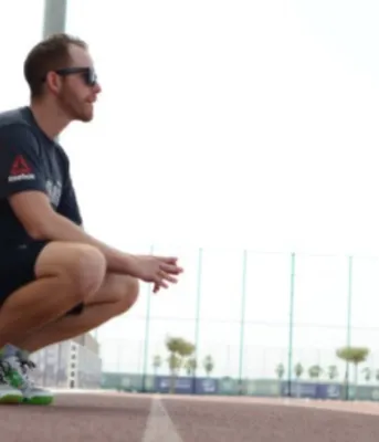 Image d'une personne qui s'étire près d'une piste de course