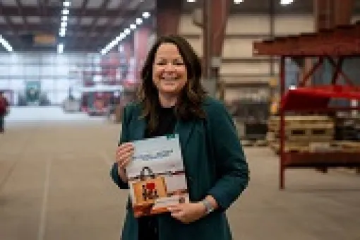Minister Jill Burridge holding a copy of the 2025-2026 Operating Budget