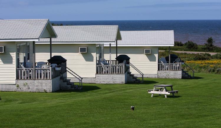 Three white cottages at waterfront in summer