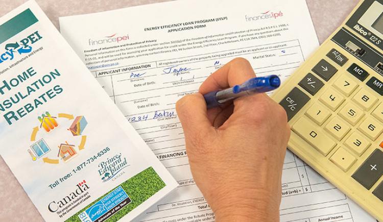 woman completing application for Energy Efficiency Loan program